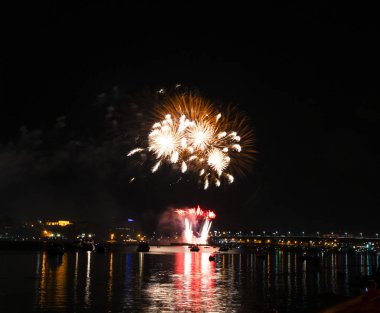 Gece gökyüzü arka plan üzerinde sarı püsküllü ve Volga Nehri üzerinde uzun bir parlama ile fireworks uygulamasından Kostroma gün festival selam
