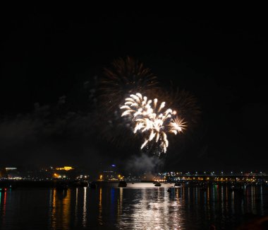 Gece gökyüzü arka plan üzerinde sarı püsküllü ve Volga Nehri üzerinde uzun bir parlama ile fireworks uygulamasından Kostroma gün festival selam