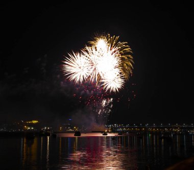 Havai fişek patlamaları renkli sarı ve mor fireballs havai fişek şeklinde şehir bugün Kostroma içinde parlak parlama ile Volga Nehri üzerinde