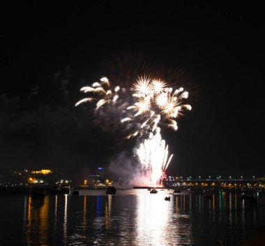 Gece gökyüzü arka plan üzerinde sarı püsküllü ve Volga Nehri üzerinde uzun bir parlama ile fireworks uygulamasından Kostroma gün festival selam
