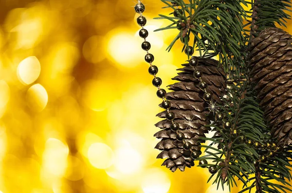 Πράσινο Χριστουγεννιάτικο Χριστουγεννιάτικο Δέντρο Κουκουνάρια Και Χρυσές Χάντρες Χρυσό Φόντο — Φωτογραφία Αρχείου