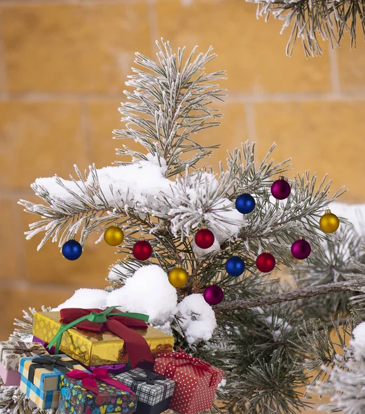 Bunte Weihnachtskugeln Den Zweigen Eines Schneebedeckten Weihnachtsbaums Und Geschenkboxen Mit — Stockfoto