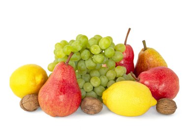 Olgun sarı limon, yeşil üzüm, ceviz ve bir meyve tabağı 