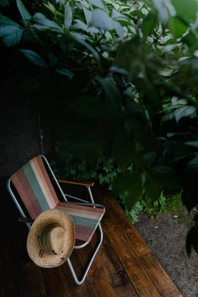 모자와 의자는 갑판에 포도나무 잎으로 둘러싸여 코티지 미학이요 밖에서 휴가를 — 스톡 사진