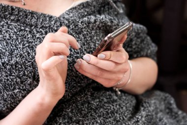 Telefon ellerinde, sosyal ağlara bağımlı, kız telefona bakıyor.