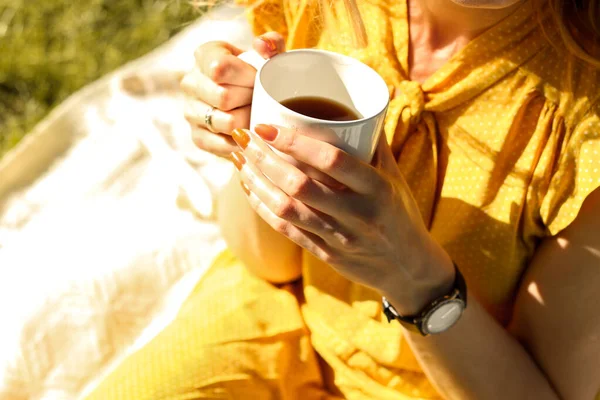 young woman drinking coffee in the park, relax in nature
