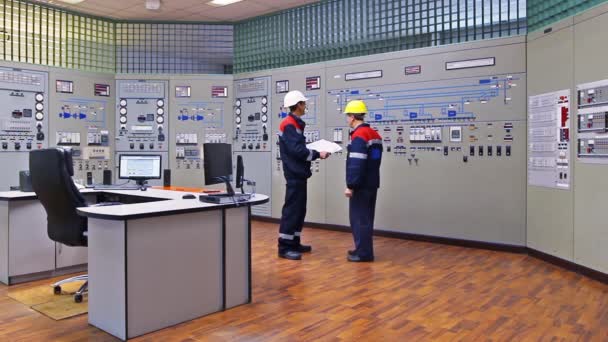 Dos ingenieros cerca del panel de control principal — Vídeos de Stock