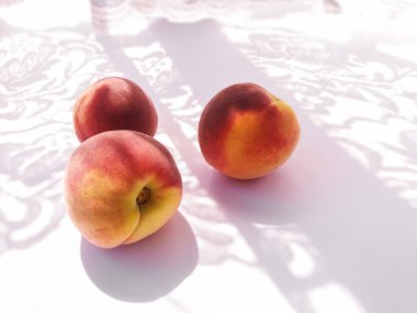 Beyaz arkaplanda taze kırmızı şeftaliler.