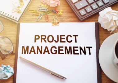 Ofis masasındaki ofis kâğıdına yazılmış Proje Yönetimi metni. İş konsepti