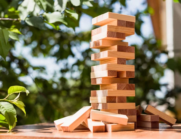 緑の木の背景を持つテーブルの上に木製のブロックタワー — ストック写真