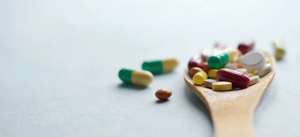 Tabletten Tabletten Und Kapseln Einem Holzlöffel Auf Einem Blauen Tisch — Stockfoto
