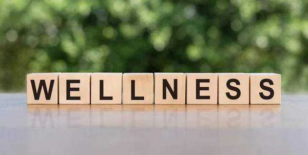 Tahta masalardaki tahta küplere WELLNESS yazılıydı. Rahatla ve dikkat et. Tıbbi ve sağlık konsepti