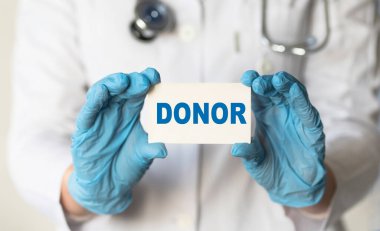 Doktorun elinde DONOR yazılı bir kart var, tıbbi konsept.