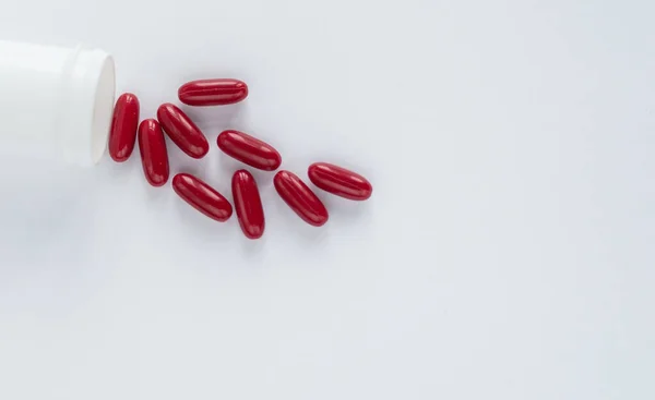 Rote Pillen Und Kapseln Einer Plastikflasche Auf Weißem Hintergrund Zur — Stockfoto