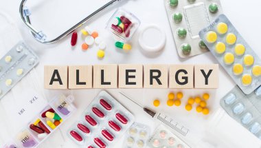 ALLERGY kelimesi, tıbbi ilaçlar ve tıbbi steteskopla beyaz arka planda bulunan tahta küplerden yapılmıştır. Tıbbi konsept.