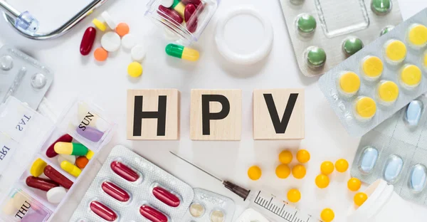 Tahta küplerle yazılmış HPV metni. HPV ile ahşap üzerine steteskop ve haplar - Tıbbi kavram olarak insan Papilloma Virüsü kelimeleri
