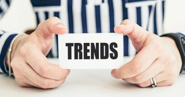 Beyaz karttaki kelime trendi kadınların elinde. İş konsepti