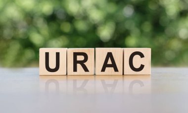 URAC kısaltması (ürik asit) tahta küplerdeki açık tahta arka plan kısaltması. Tıp konsepti.