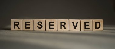Gri masadaki yapı taşlarıyla yapılmış RESERVED sözcüğü