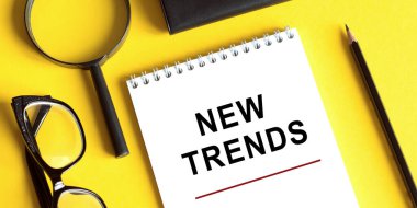 Not defterine gözlüklü, kalem ucunu büyüten yeni trend metni yazıldı. Bir şeyleri değiştirmenin ana trendi. Popüler ve ilgili konular. İş hayatında yeni trendler. Yeni ve son moda. Değerlendirme yöntemleri.