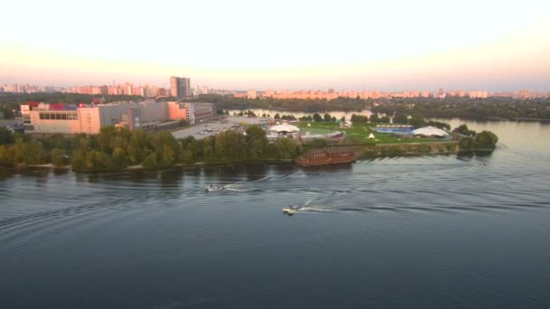 Drohnenflug aus der Luft: Menschen fahren auf dem Brett hinter dem Boot. — Stockvideo