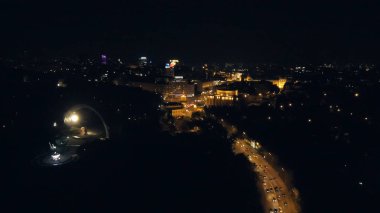 Drone havadan görünümden: üzerinde yol ve gece ışıkları uçan gece şehir.