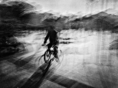 Sokaktaki bisikletlinin uzun soluklu görüntüsü.