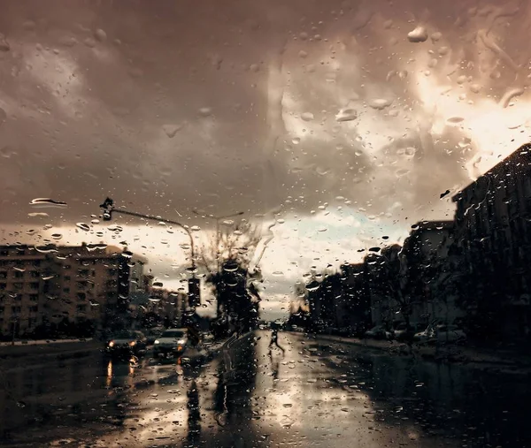 Dağınık şehir manzaralı camlara yağmur damlaları.