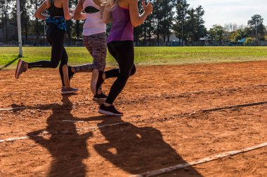 Koşu pistinde koşan üç genç kadın