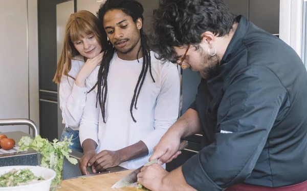 Chef teaching a multiracial couple how to make a meal