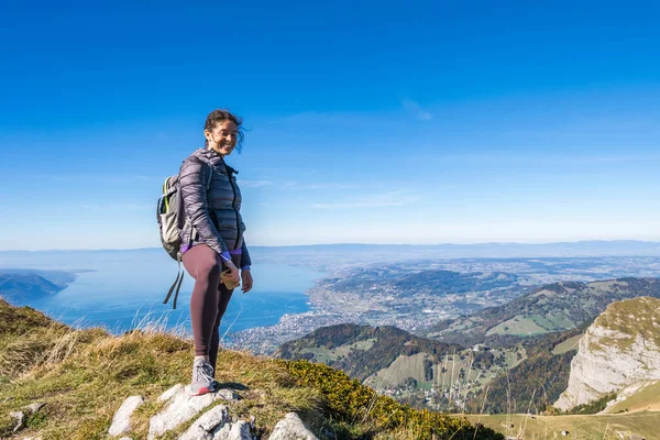 Mujer joven excursionista con mochila en una cima de la montaña contra el fondo del cielo. Concepto de viaje . — Foto de Stock