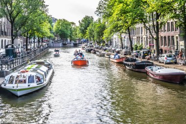 Amsterdam, Hollanda - 18 Temmuz 2018: Kanallarda Yaşam. Kanaldaki mavnalar ve yan sokaklardaki araçlar.