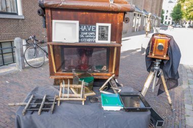 Amsterdam, Hollanda - 19 Temmuz 2018: Sokak fotoğrafçısı eski analog kamera kullanarak turistlerin fotoğraflarını çekiyor