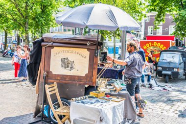 Amsterdam, Hollanda - 19 Temmuz 2018: Sokak fotoğrafçısı eski analog kamera kullanarak turistlerin fotoğraflarını çekiyor