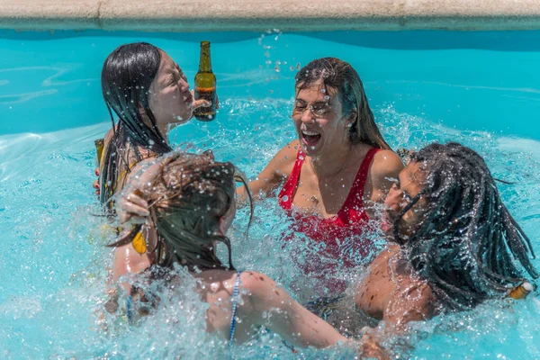 People from different ethnicities hugging each other stirring the water in a pool