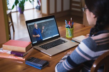 Matematik öğretmeniyle online ders izleyen genç bir öğrenci. Çevrimiçi Eğitim ve e-öğrenim. Koronavirüs salgını zamanında evden ders çalışmak