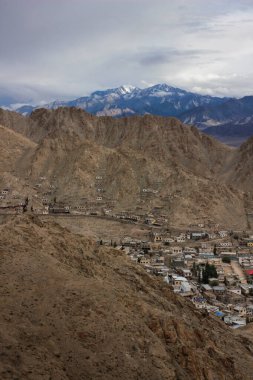 Himalaya 'nın engebeli dağlarında evler inşa edilir. Leh Şehri ve görkemli Himalaya Dağları (Hindistan))