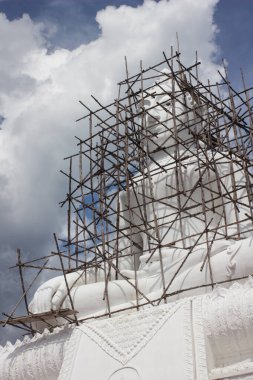 Bambu iskelesiyle kaplanmış Buda Heykeli. Asya Ülkesi 'nde (Tayland) büyük beyaz Budist heykeli onarılıyor)