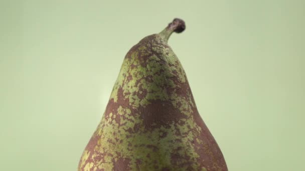 Conference Pear on Green Background. Creative rotating macro shot of fresh and healthy fruit — Stock Video