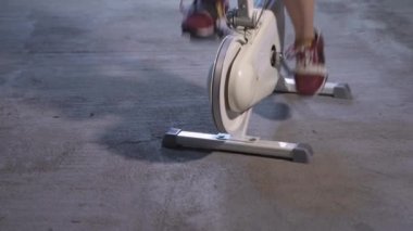 Sabit Bisiklet Üzerinde Egzersiz Yapan Mutlu Genç Kadın. Kapalı alan Sağlıklı Spor