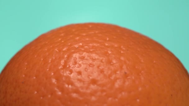 Orange Fruit Macro Close up on turquoise blue background. Creative rotating macro shot of fresh and healthy fruit — Stock Video