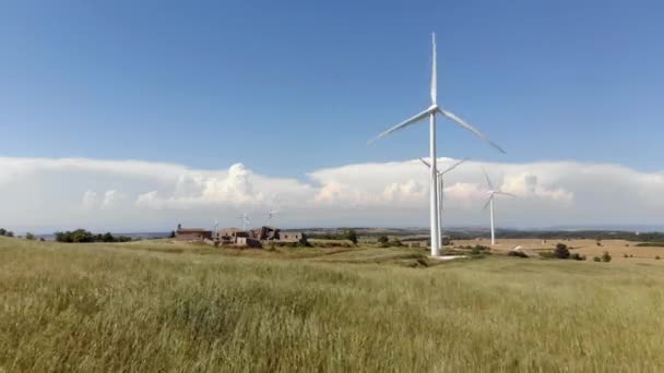 Větrné turbíny v zemědělské venkovské krajině, s krásným pšeničným polem během větrného dne (bezpilotní pohled). Technologie pro udržitelnou obnovitelnou energii — Stock video