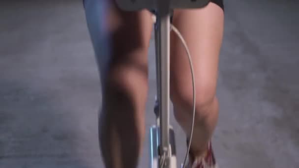 Jonge vrouw aan het trainen op Spinning Bike. Thuis workout indoor stationaire fiets — Stockvideo