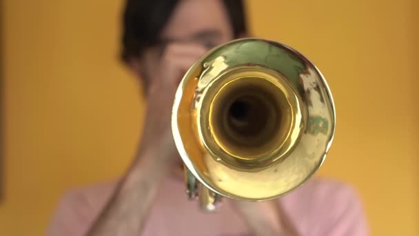 Músico tocando uma velha trombeta em uma sala amarela — Vídeo de Stock