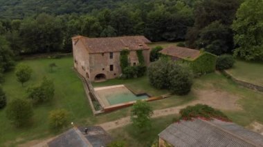 Kırsaldaki eski güzel taş çiftliğinin canlı stoklar için tarlaları olan havadan çekilmiş bir fotoğrafı.