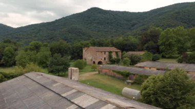 Kırsaldaki eski güzel taş çiftliğinin canlı stoklar için tarlaları olan havadan çekilmiş bir fotoğrafı.