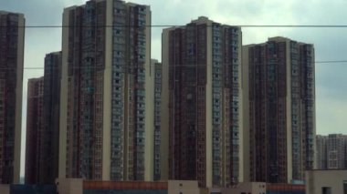 Çin kasabasında, hareket halindeki bir trenin penceresinden görülen konut kuleleri.