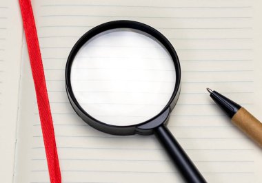 Notepad 'in beyaz boş sayfasında yakın çekim büyüteç, üst manzara. Arama kavramı