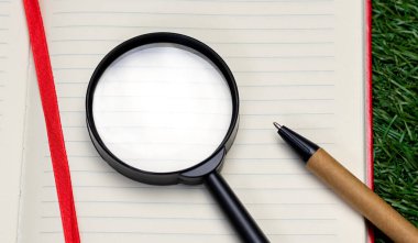 Notepad 'in beyaz boş sayfasında yakın çekim büyüteç, üst manzara. Arama kavramı