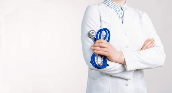 Cropped view of Woman Doctor in uniform standing and holding a stethoscope. Copy space for your text